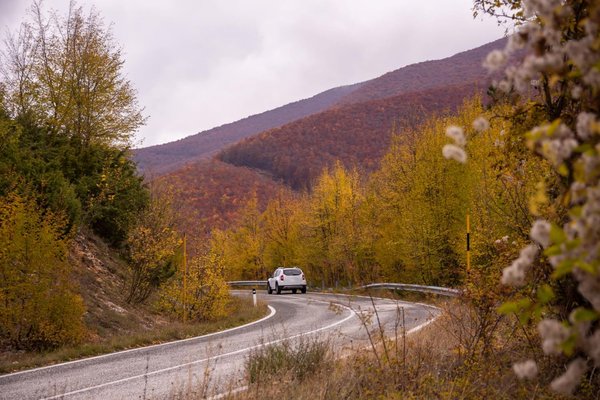 Car on a winding mountain road in autumn