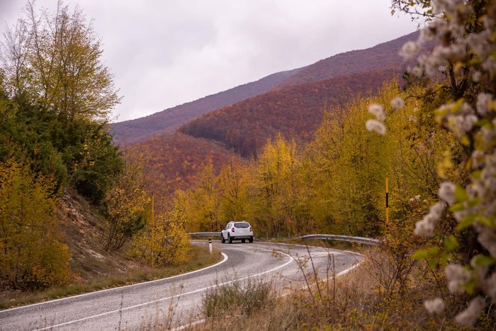 Car on a winding mountain road in autumn