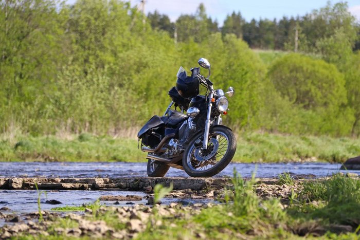 Cruiser motorcycle parked beside a stream